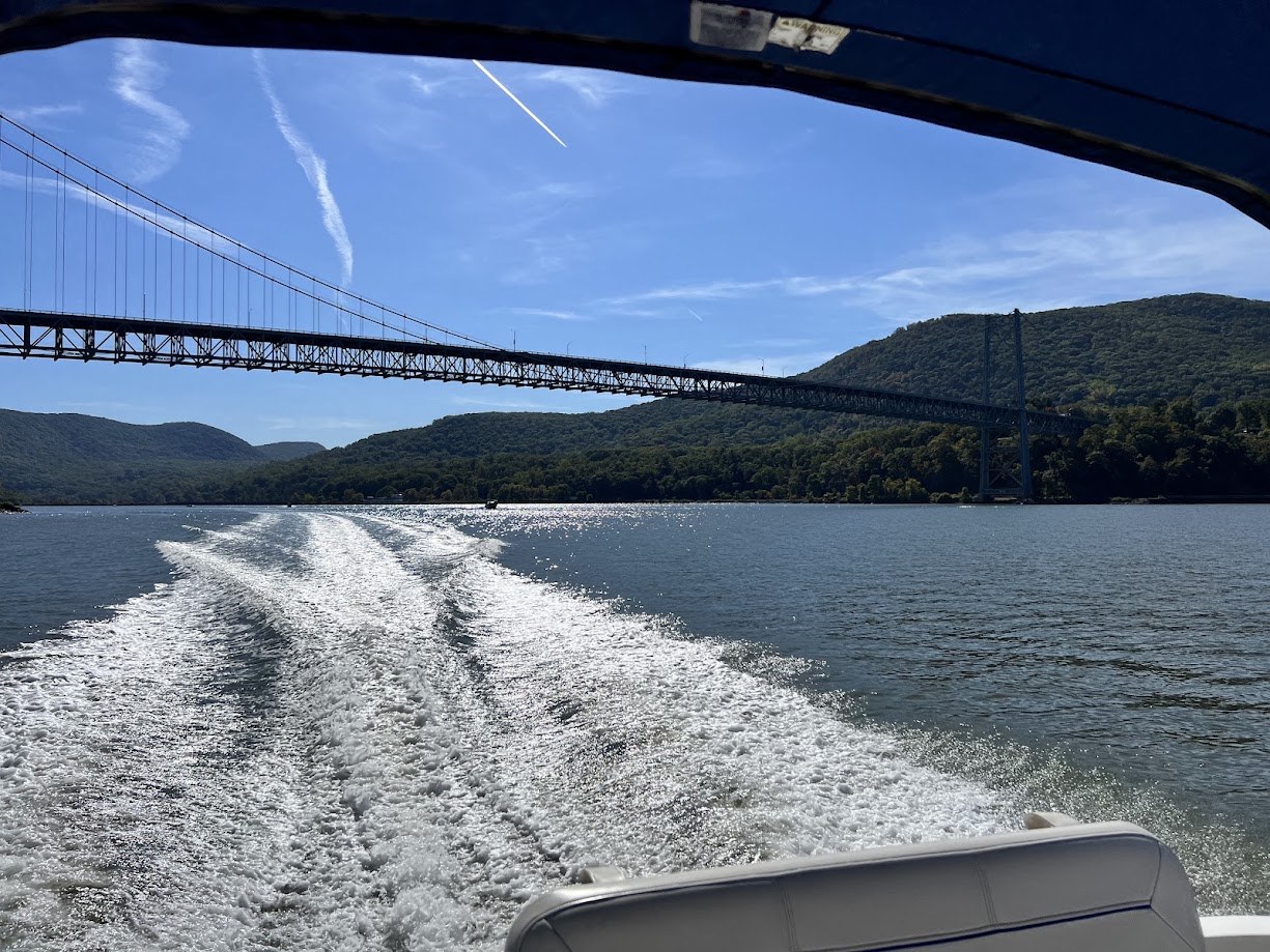 Suspension bridge over the Hudson River, viewed from a boat's wake